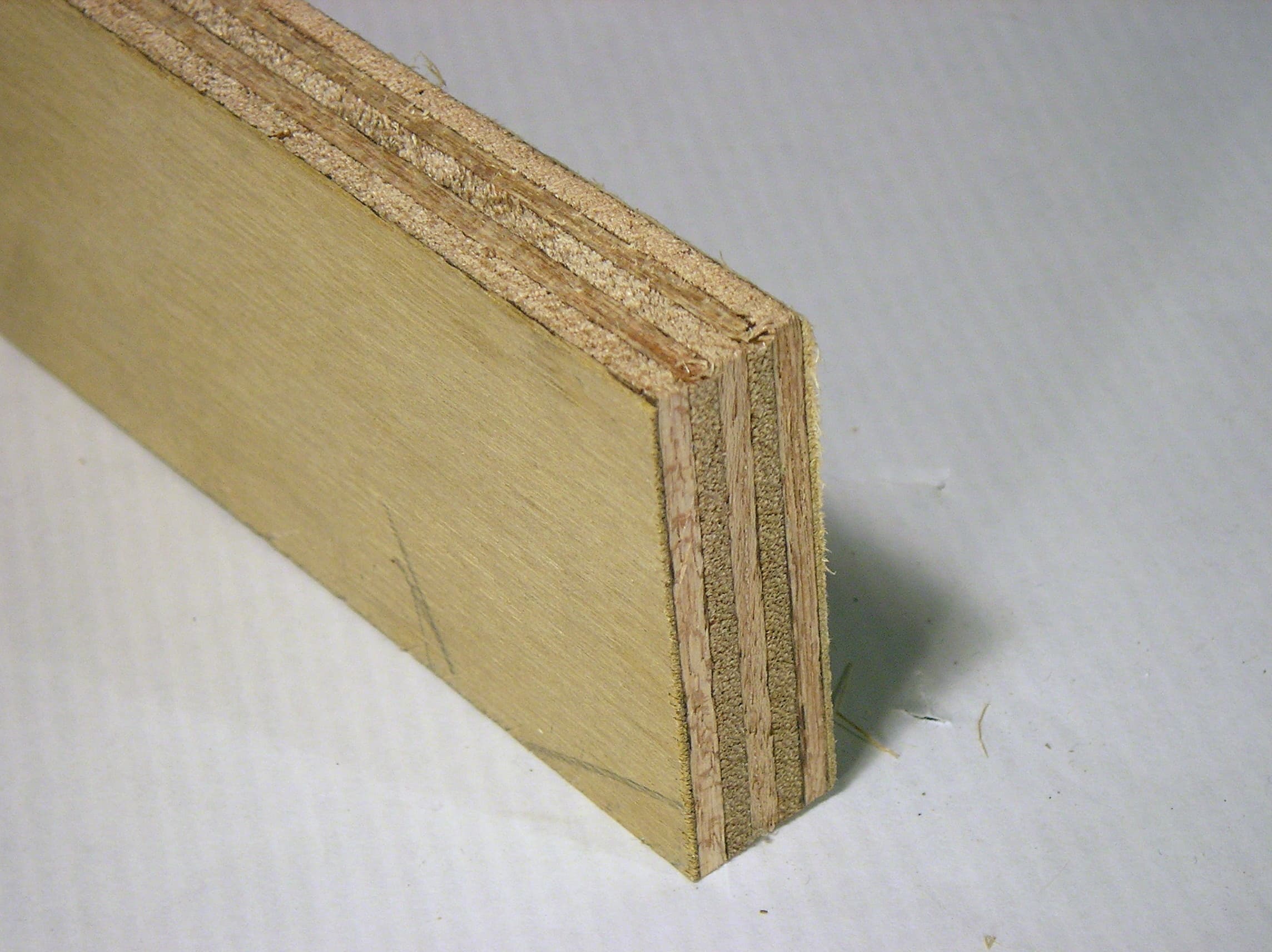 Plywood sample showing its broad wood face and layered cut edges — reference photo, not the exact supplied product