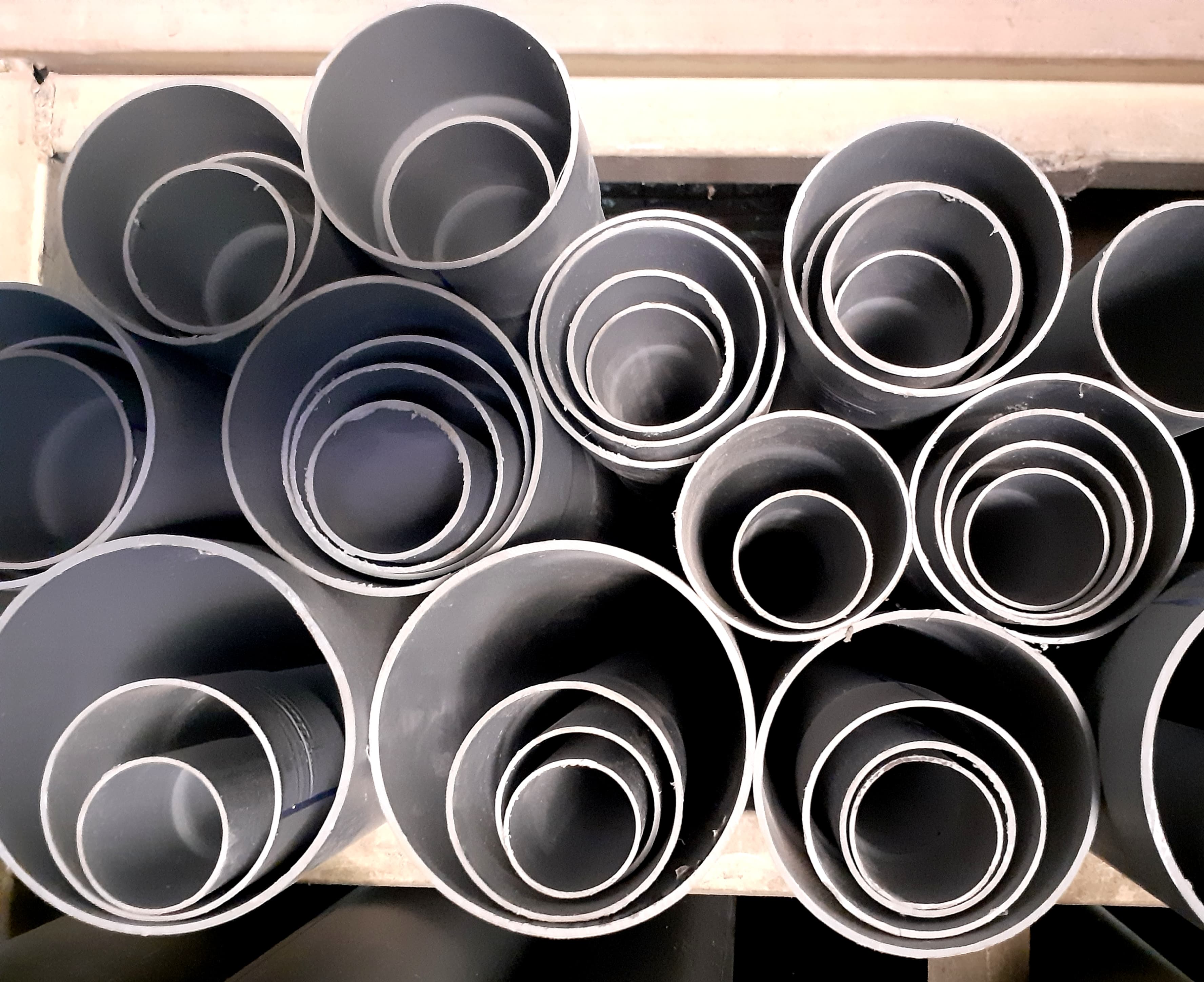Grey straight PVC pipes with visible round open ends — reference photo, not the exact supplied product