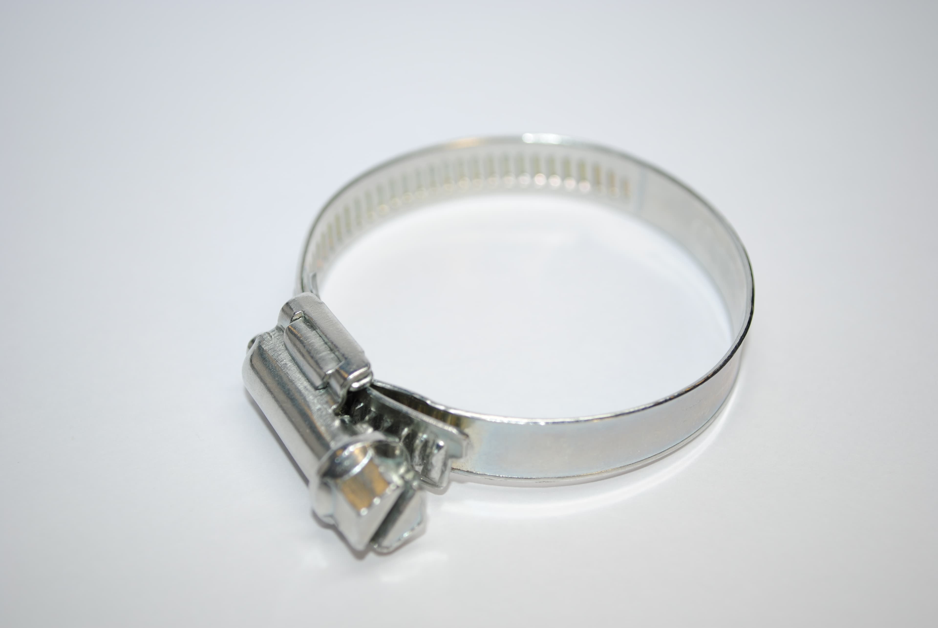Metal worm-drive hose clamp with its screw housing and perforated band visible — reference photo, not the exact supplied product